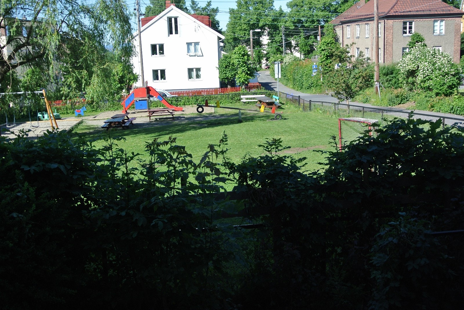 Utsikt fra stuevindu: Friareal, lekeplass utenfor hekk Galleribilde