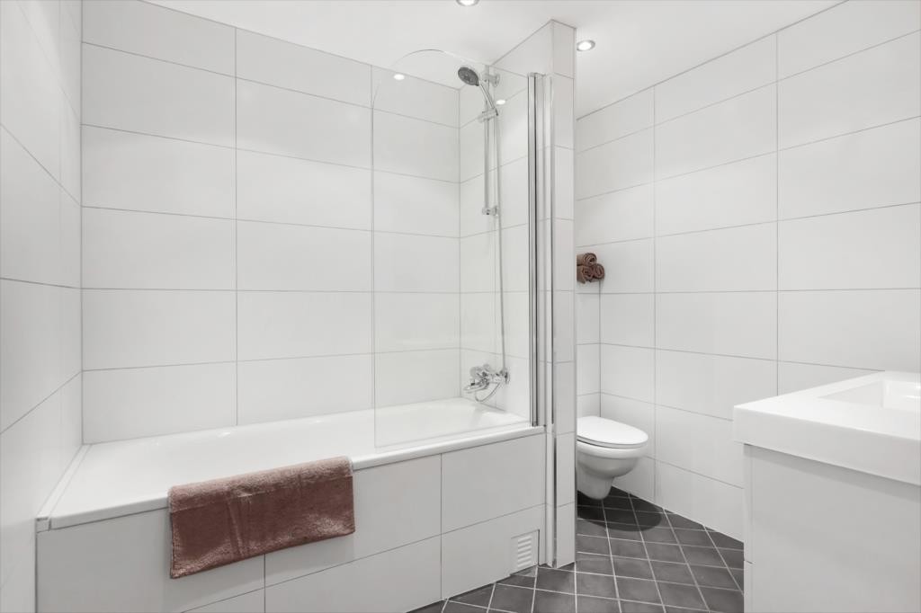 Meget pent flislagt bad med varmekabler i gulv, og dimbare downlights i himling. Galleribilde