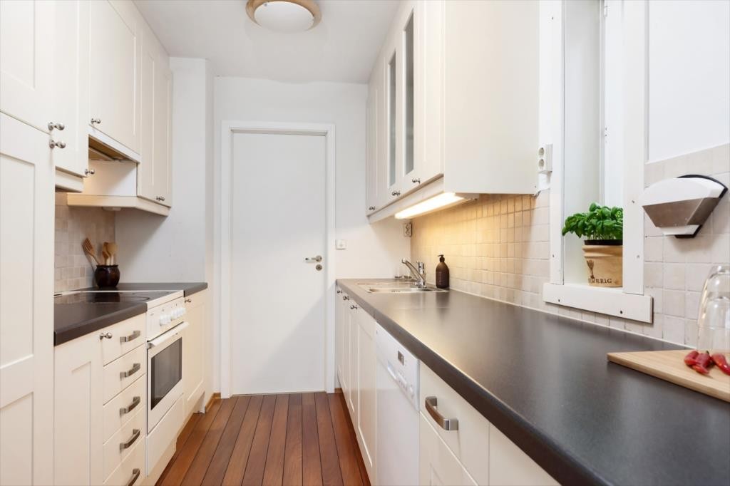 Gode arbeidsforhold på kjøkken. Fliser og belysning over benk. Galleribilde