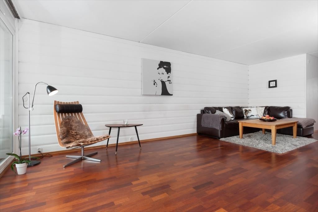 Romslig stue med merbauparkett på gulv og malte flater. Galleribilde