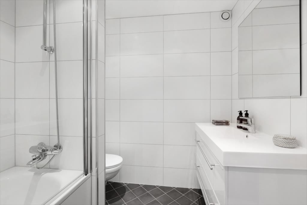 Meget pent bad med fornyet i 2015 med nye fliser på vegg og ny heldekkende servant med servantskuffer og speil på vegg. Innmurt badekar med ny dusjgarnityr, samt ny innfellbar dusjvegg i herdet glass. Galleribilde