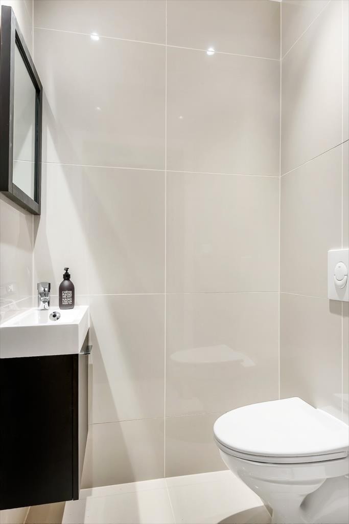 Separat og praktisk wc med flislagt gulv og vegger, malt himling med dimbare downlights. Varmekabler i gulv. Galleribilde