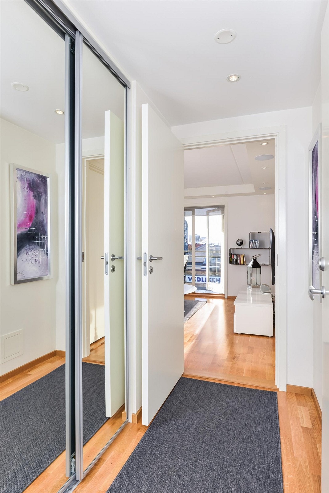 Entre med speil-skyvedørsgarderobe som tar deg videre inn i leiligheten eller til badet. Gå videre for å se hva som venter deg... Galleribilde