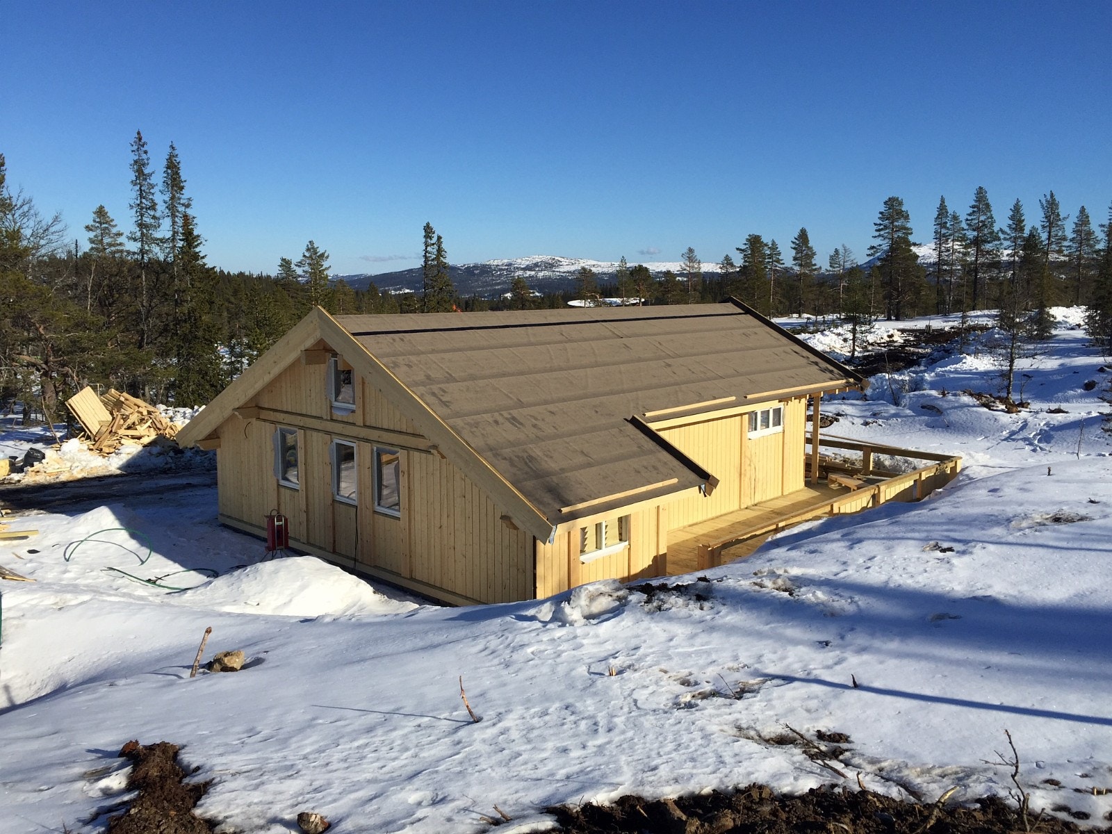 Tilsvarende hytte men med forlenget gavel, ekstra bod samt utvdet terrasse under oppføring Galleribilde