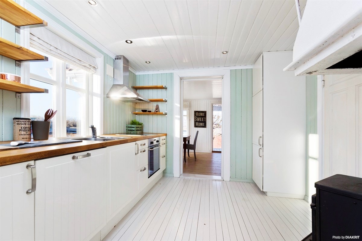 Kjøkkeninnredningen har folierte skapstammer og massive benkeplater. Dels integrerte hvitevarer. Galleribilde