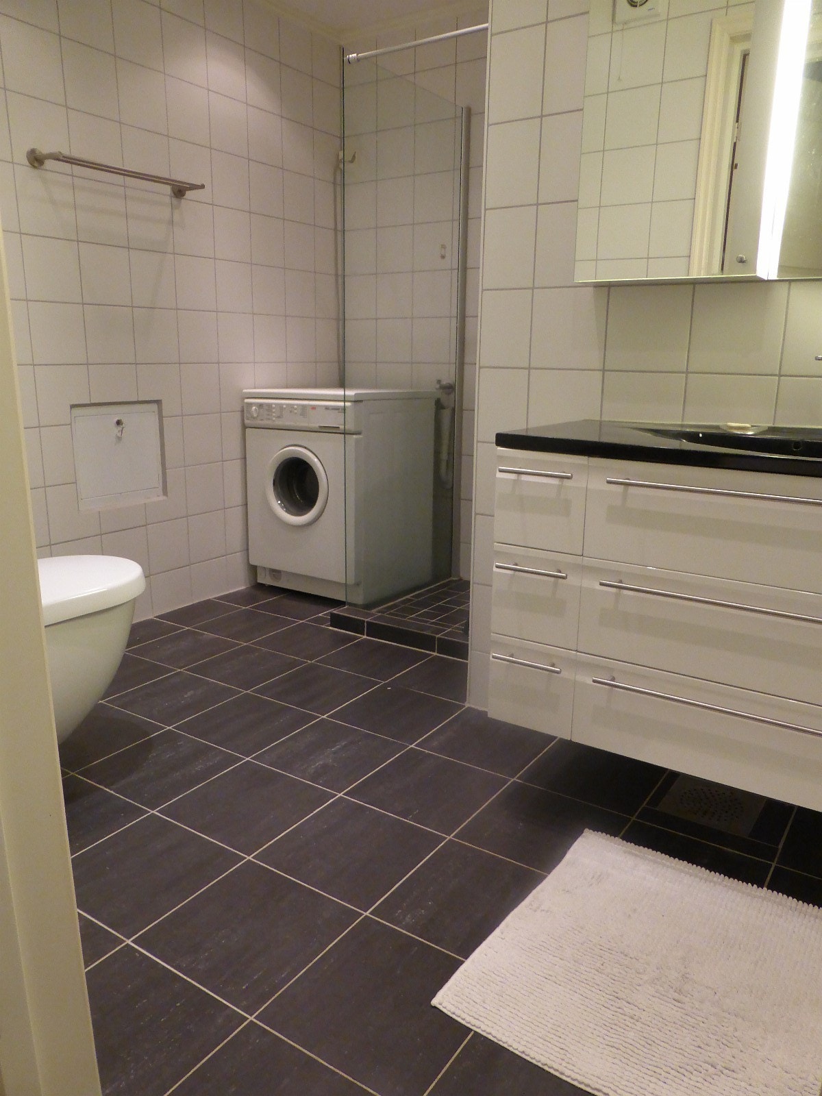 Flislagt bad, dusjhjørne med glassvegg, samt vaskemaskin inkludert i leieprisen Galleribilde