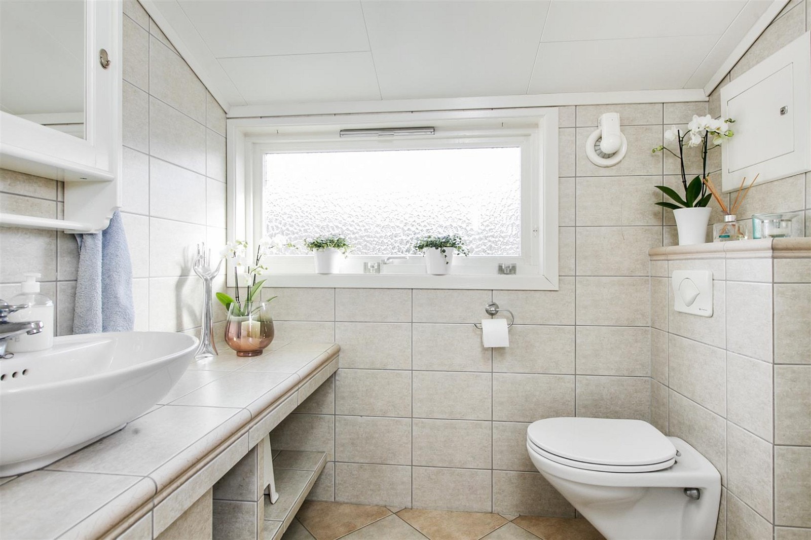 Moderne og pent bad fornyet i 2009. Badet har dusjkabinett, servant med flislagte hyller og vegghengt toalett. Galleribilde