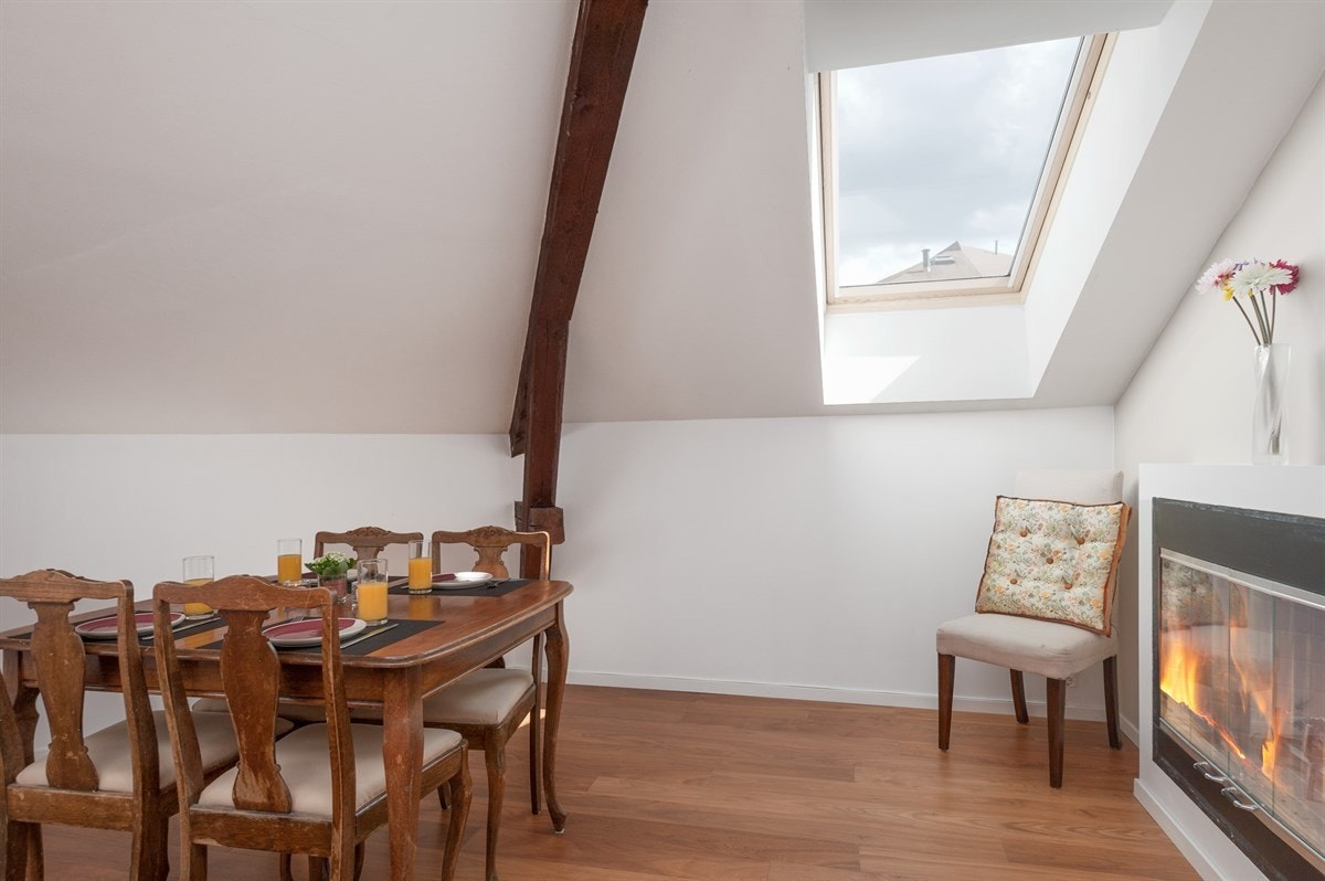 Foran spisebordet i kjøkkenet er det nok en peis. Galleribilde