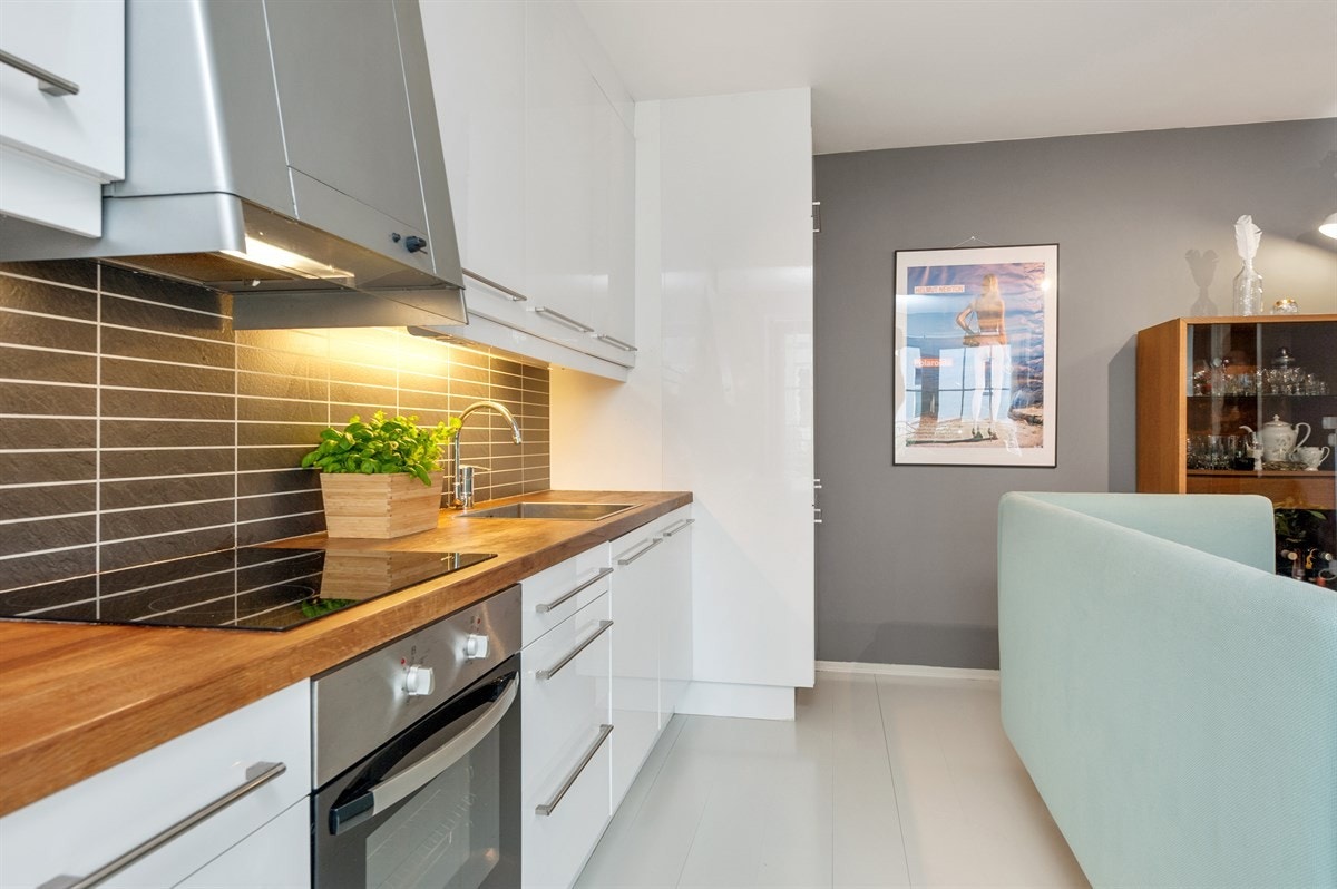 Kjøkkenet er lekkert og moderne. Det er god plass til å sette opp et spisebord eller en kjøkkenøy mellom rommene, noe som vil gi et naturlig og pent skille. Galleribilde