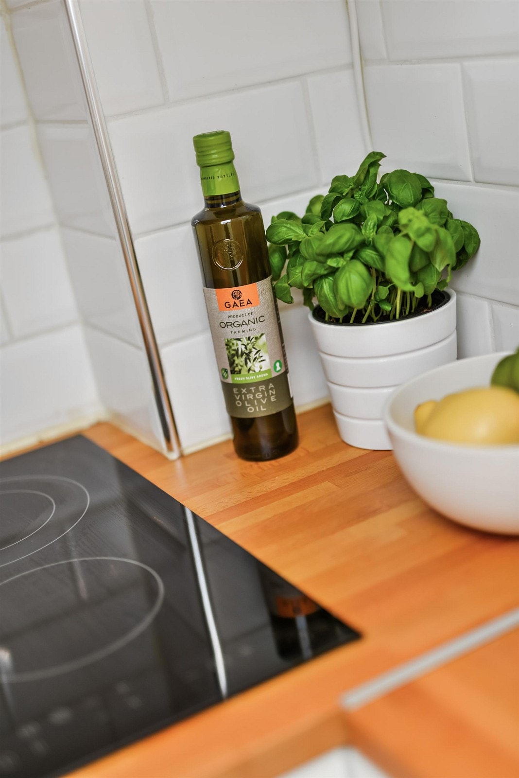 Detalj fra kjøkken; flotte fliser over heltre benkeplate, integrert platetopp. Galleribilde