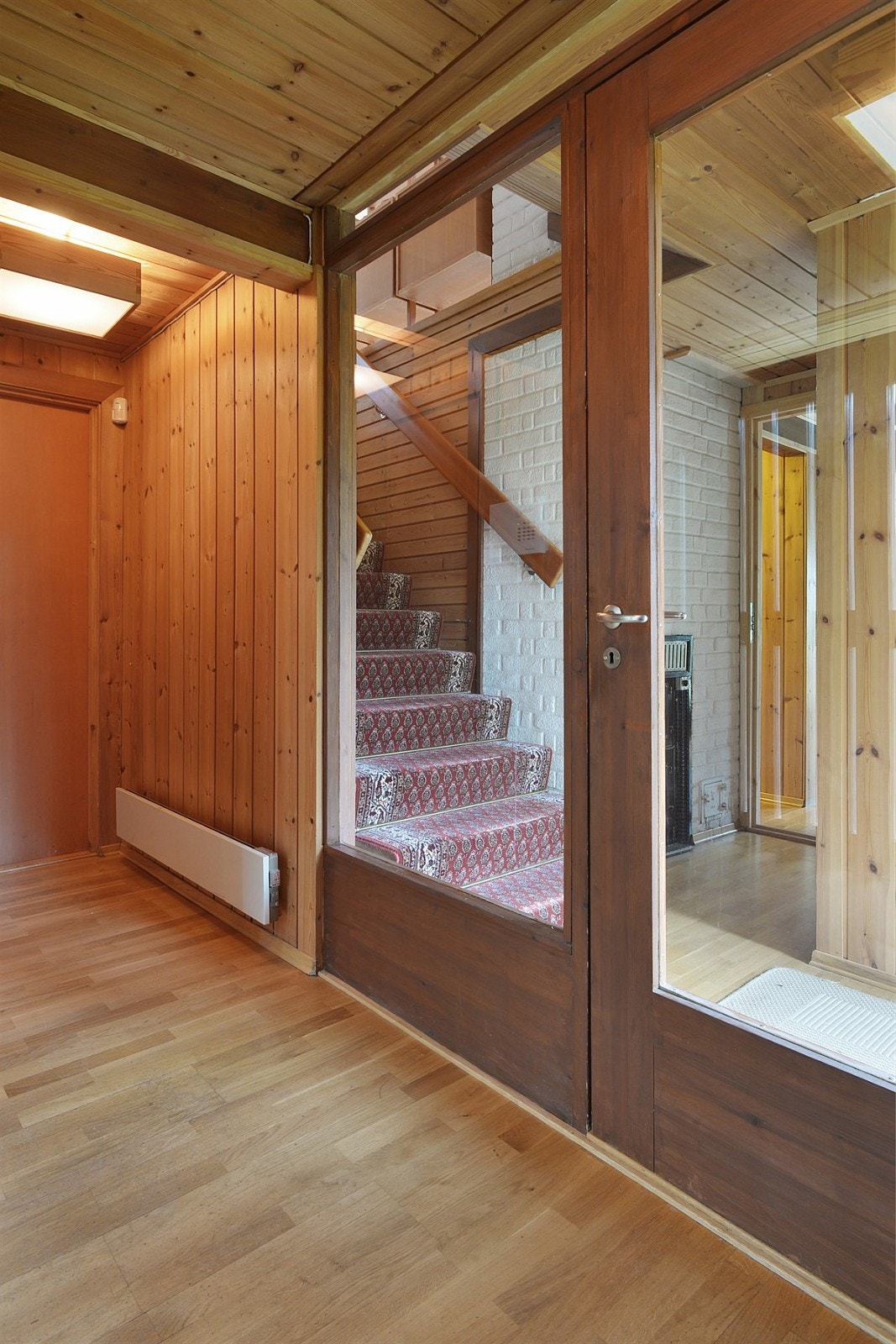 Fra entreen er det adkomst via glassdør til romslig gang med parafinovn, samt teppebelagt trapp opp til gang i første etasje. Gangen i første etasje har flere garderobeskap, samt utgang til terrasse Galleribilde