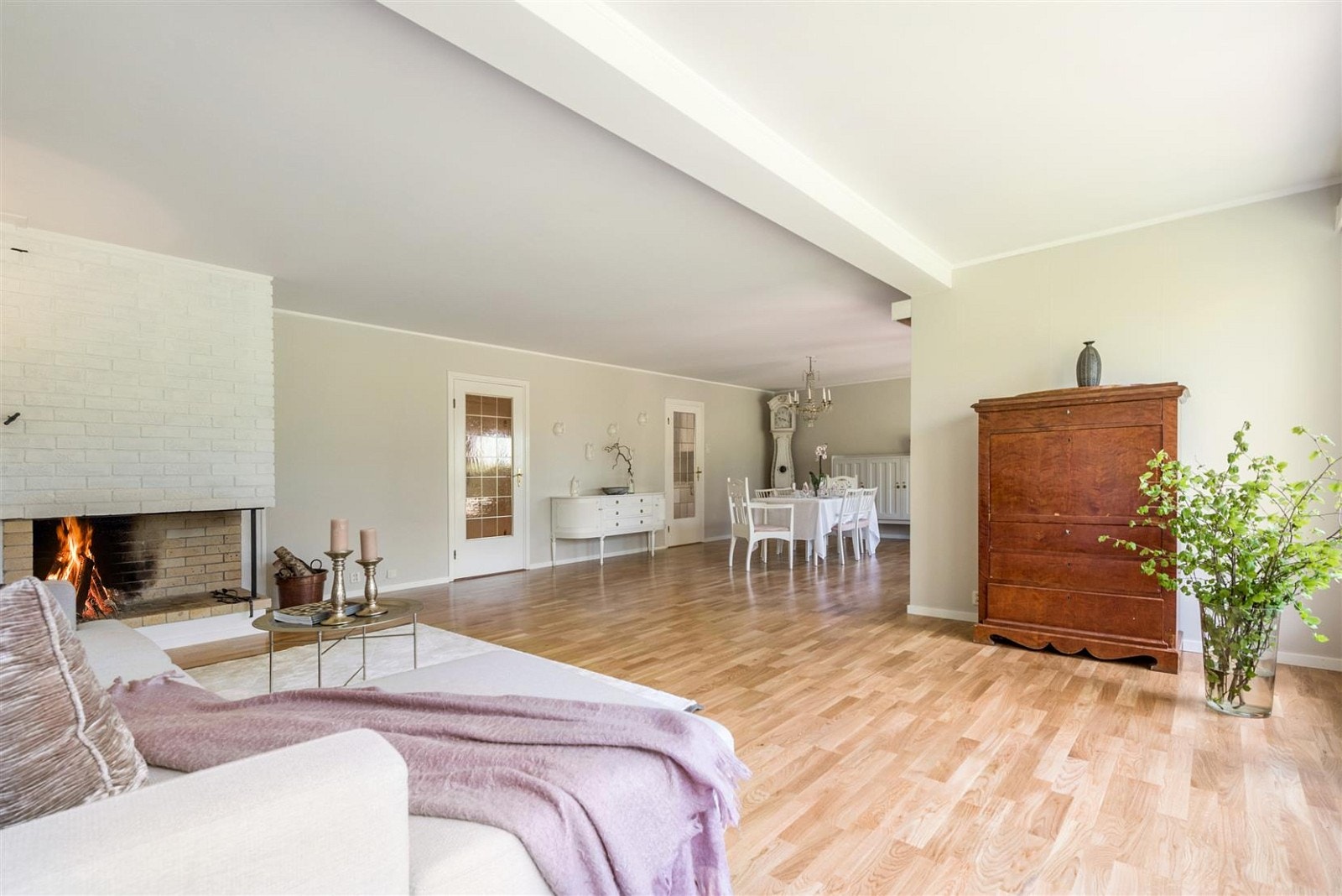 Stor stue/spisestue med peis og utgang til terrasse og hage. Galleribilde