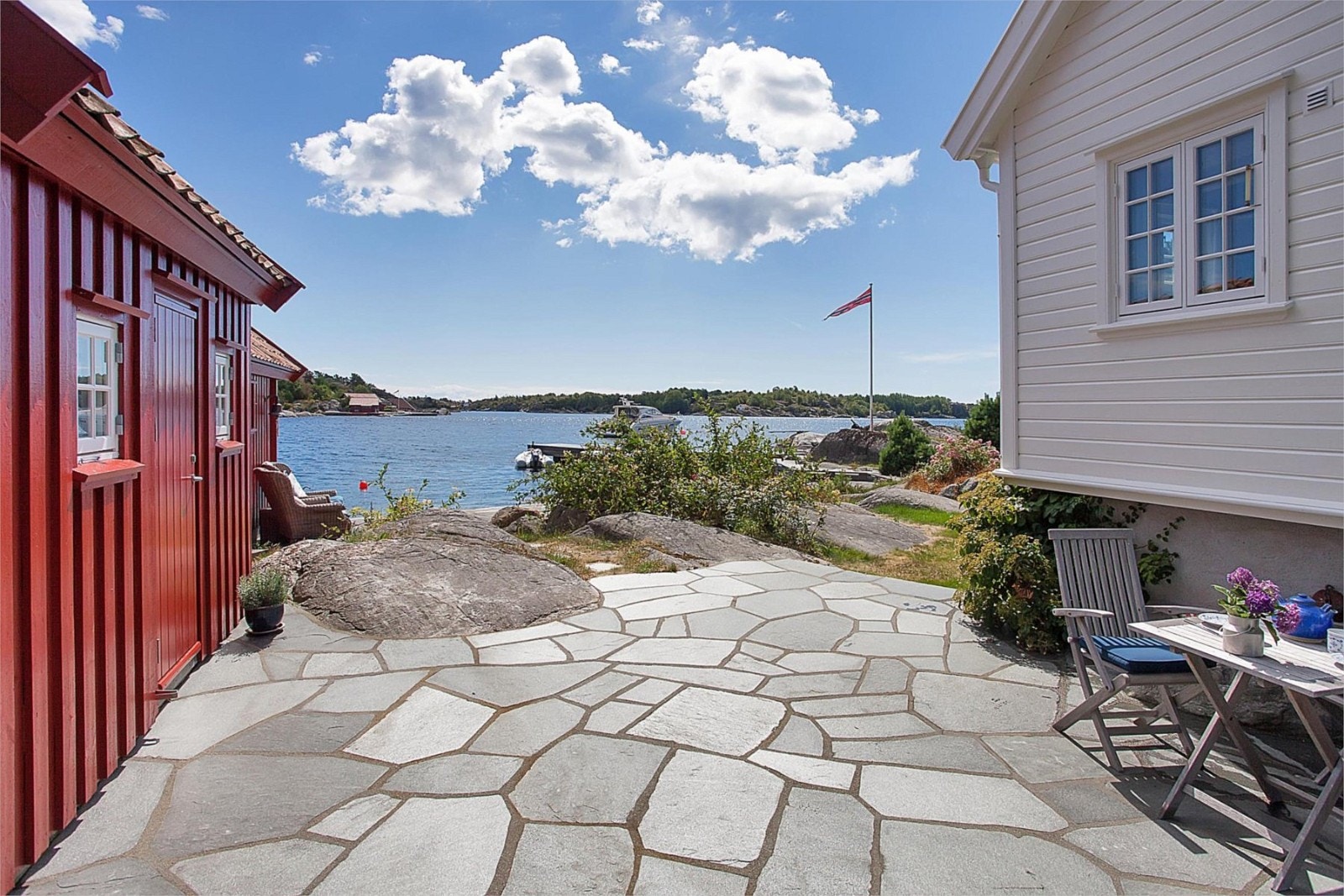 Flott hellelagt platting mellom hytte og gjesteanneks Galleribilde