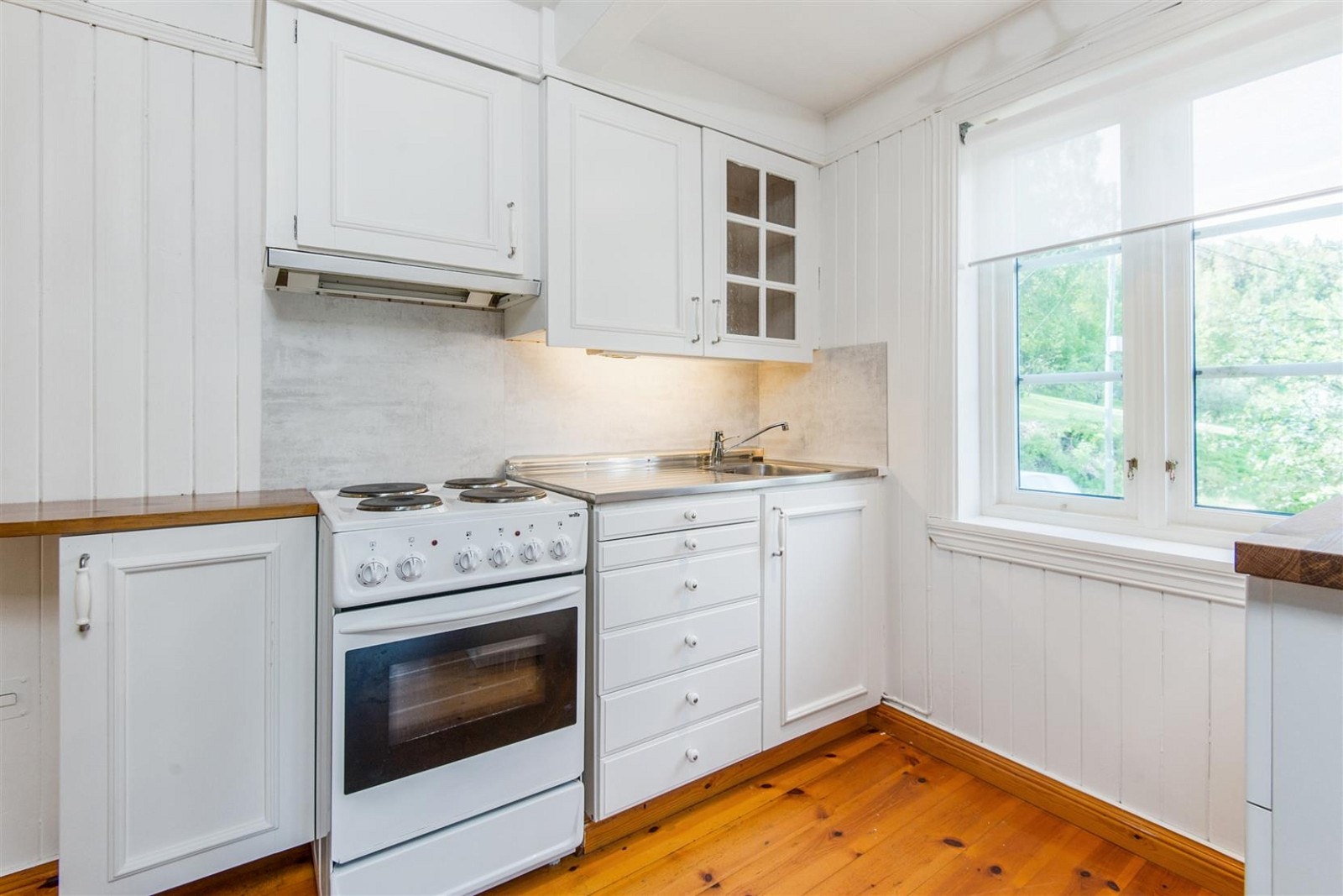 Hvit, enkel innredning på kjøkkenet. Galleribilde