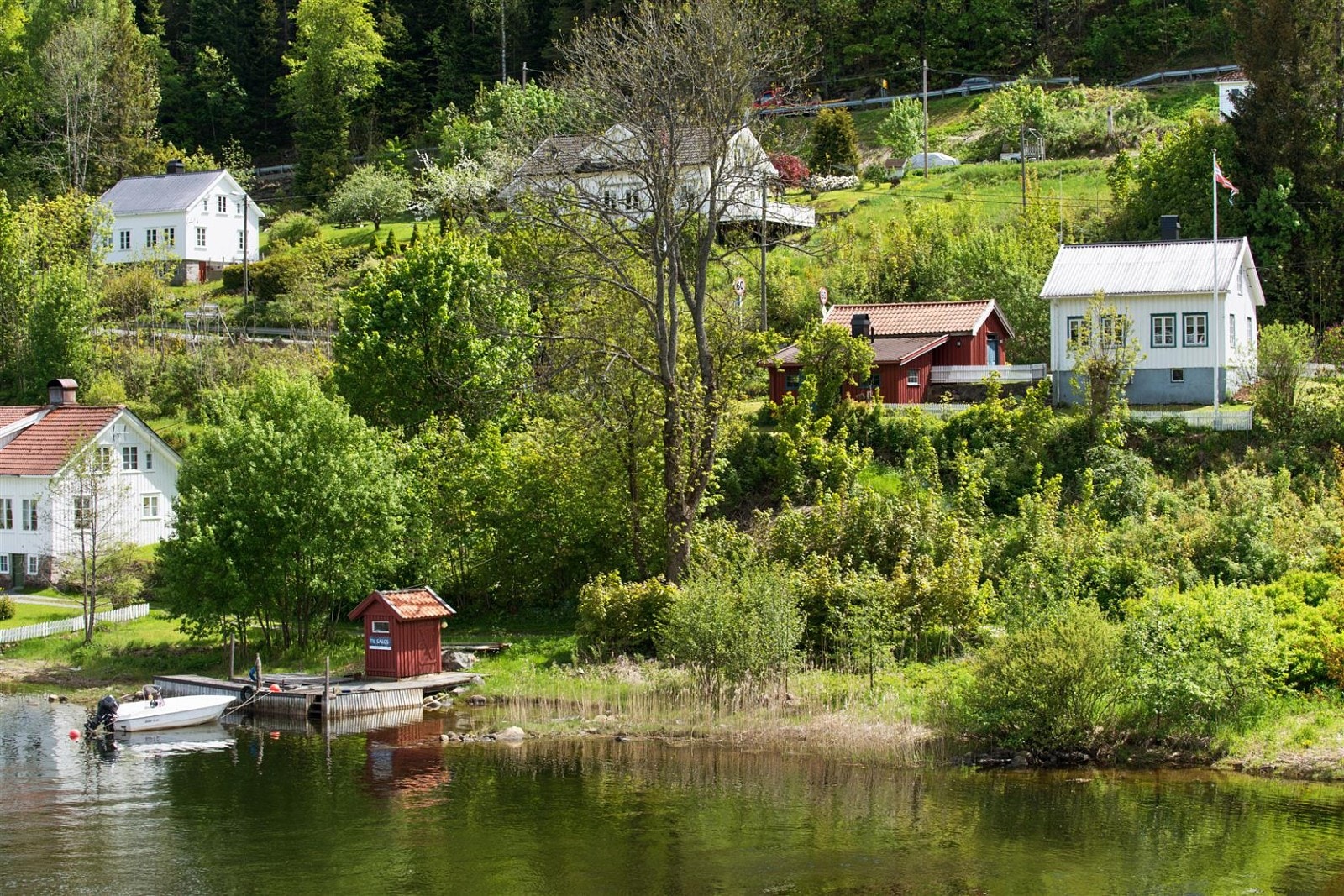Oversiktsbilde som viser boligen, uthuset og brygga med naust. Galleribilde