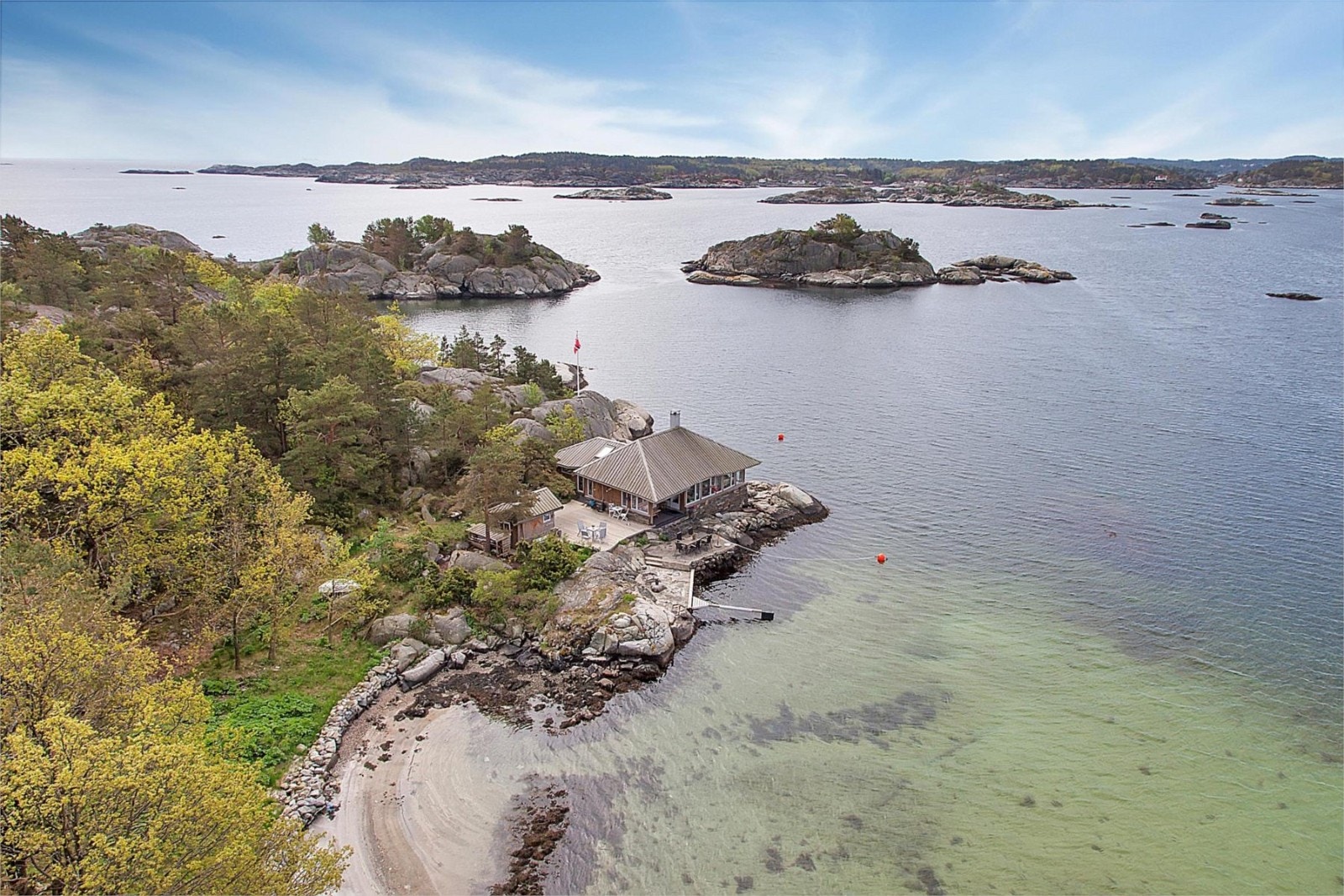 Flyfoto over eiendommen med sandstrand på innsiden Galleribilde
