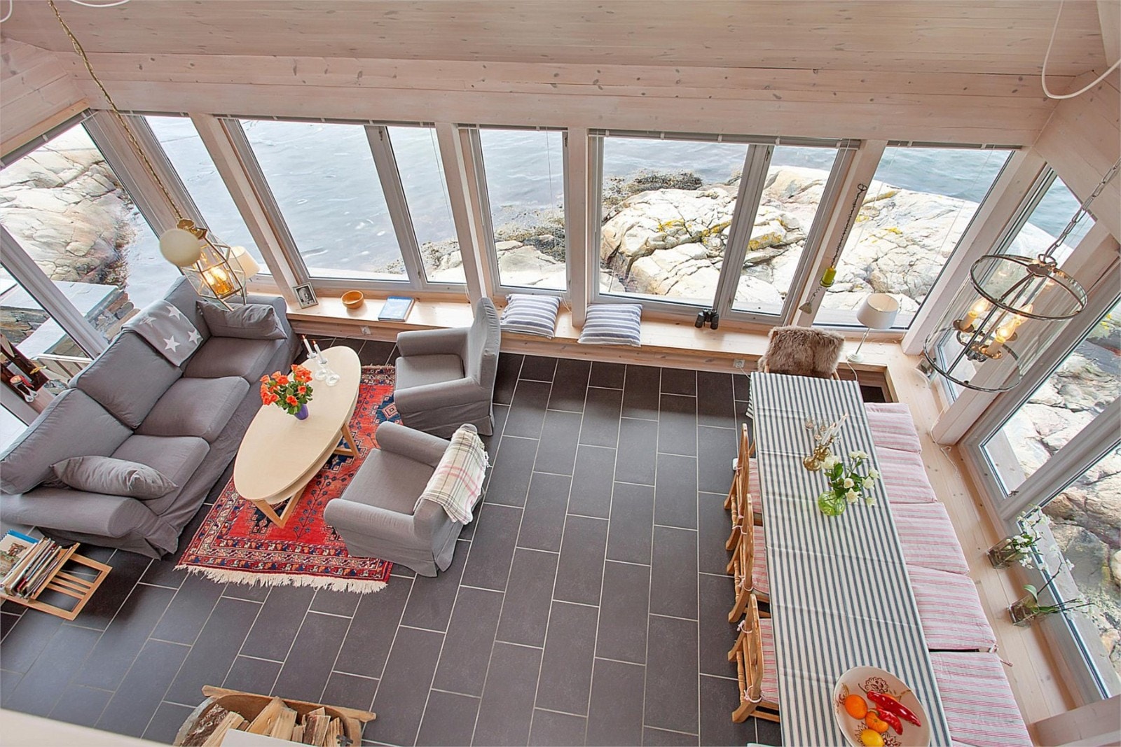 Bilde fra stuen hvor man har store vinduer vendt ut mot sjøen Galleribilde