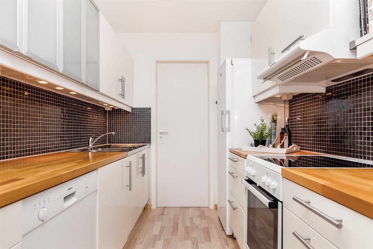 Kjøkkenet er praktisk innredet med god skap- og benkeplass. Inngang til vaskerom. Galleribilde