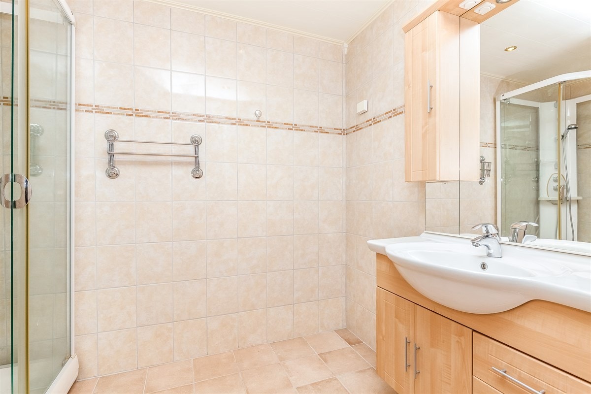 Bad nr. 2. Delikat flislagt dusjbad med wc og opplegg for vaskemaskin/tørketrommel. Gulvvarme og downlights i himling. Galleribilde