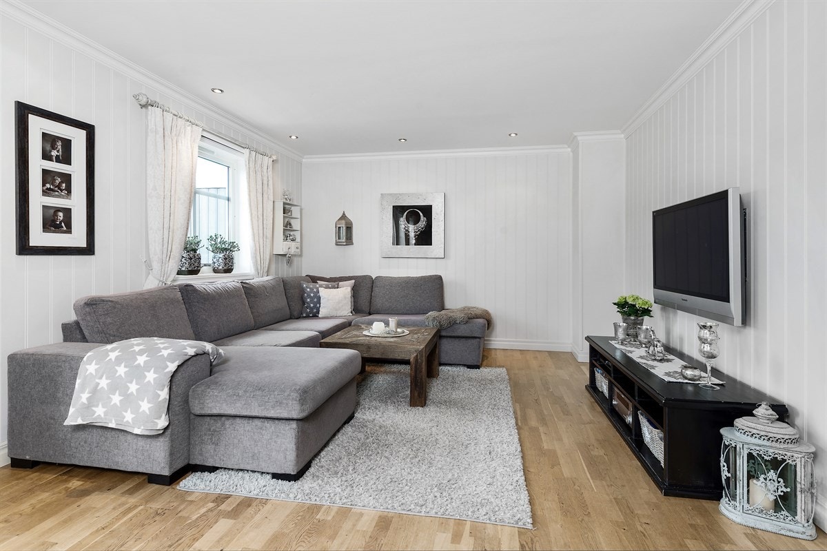 Tomannsboligen har en romslig og tiltalende stue med åpen løsning mot kjøkken, noe som gir en romslig og sosial arena. Galleribilde