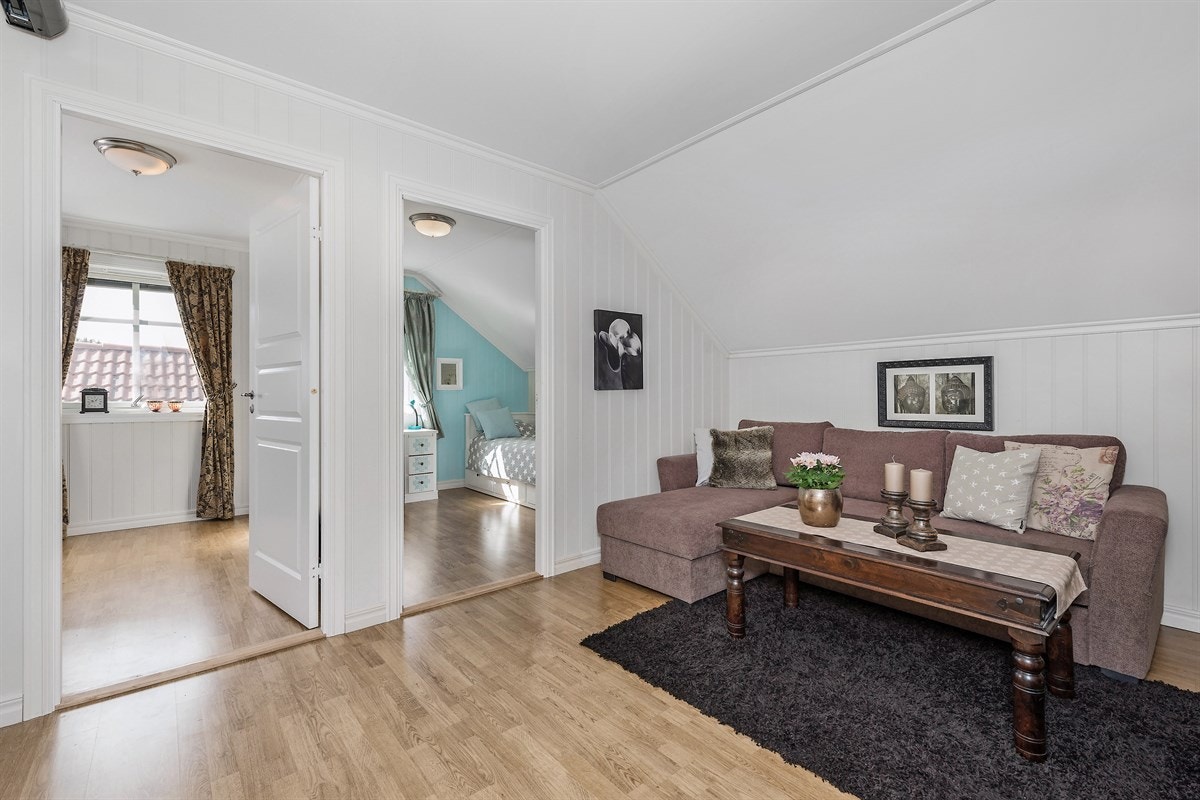 Andre etasje har en lys og romslig stue med laminat på gulv og hvitmalte vegger. Galleribilde