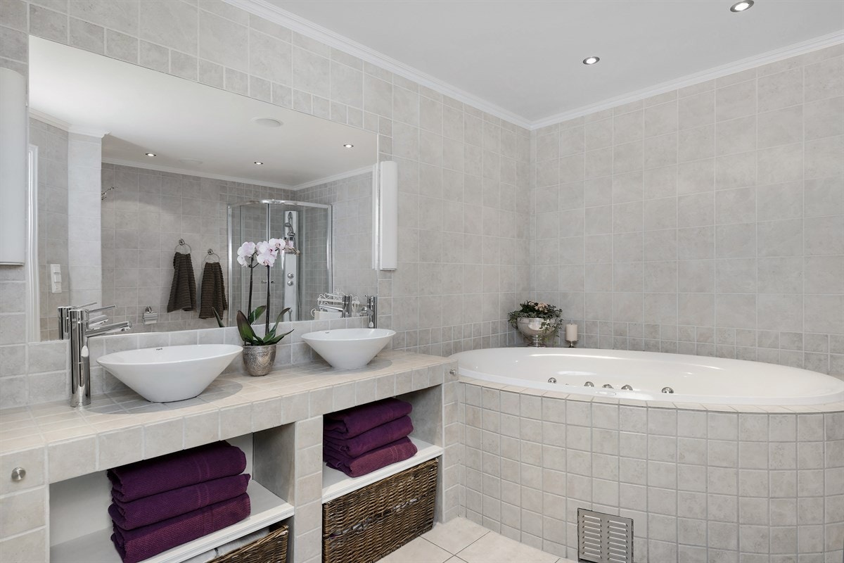 Boligen inneholder ett delikat bad, separat wc og separat vaskerom. Badet har sandfargede fliser på gulv med gulvvarme, matchende fliser på vegg, downlights i tak, integrerte høyttalere og elektrisk avtrekksvifte. Galleribilde