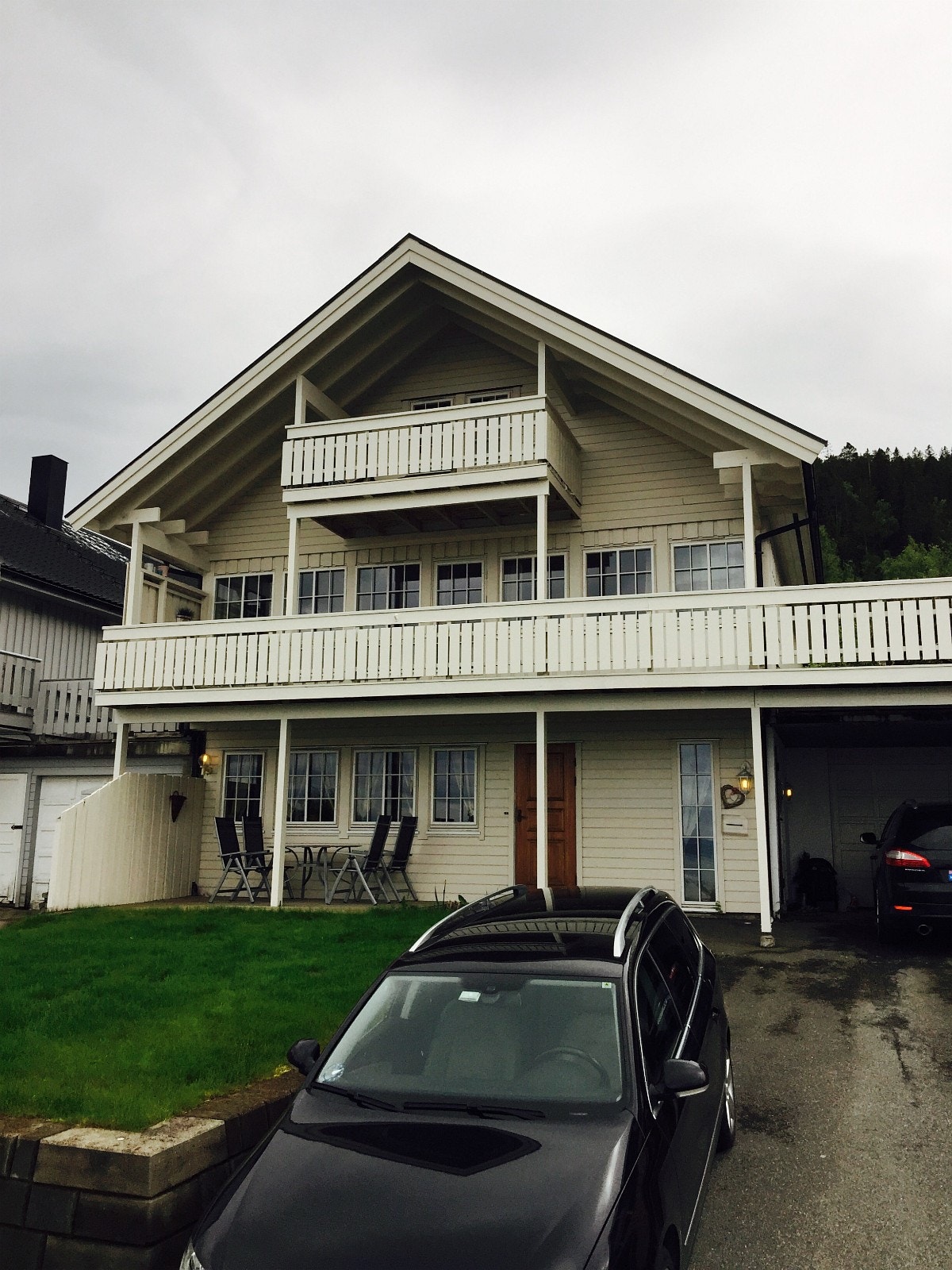 Sokkelleilighet sett fra utsiden med inngang i front samt egen p-plass for bil inntil muren Galleribilde