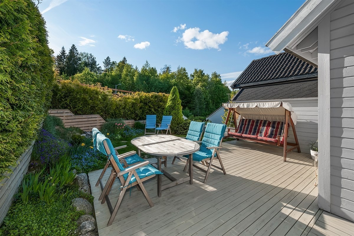 Boligen har en idyllisk, skjermet hage med stor markterrasse, pene blomsterbed, gjerde, vintergrønn hekk og plen. Solen treffer terrassen fra ca. kl. 08-20 om sommeren. Galleribilde