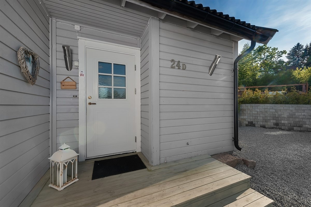 Eneboligen har et hyggelig inngangsparti med velkomst-tram og overbygg over ytterdøren. Galleribilde