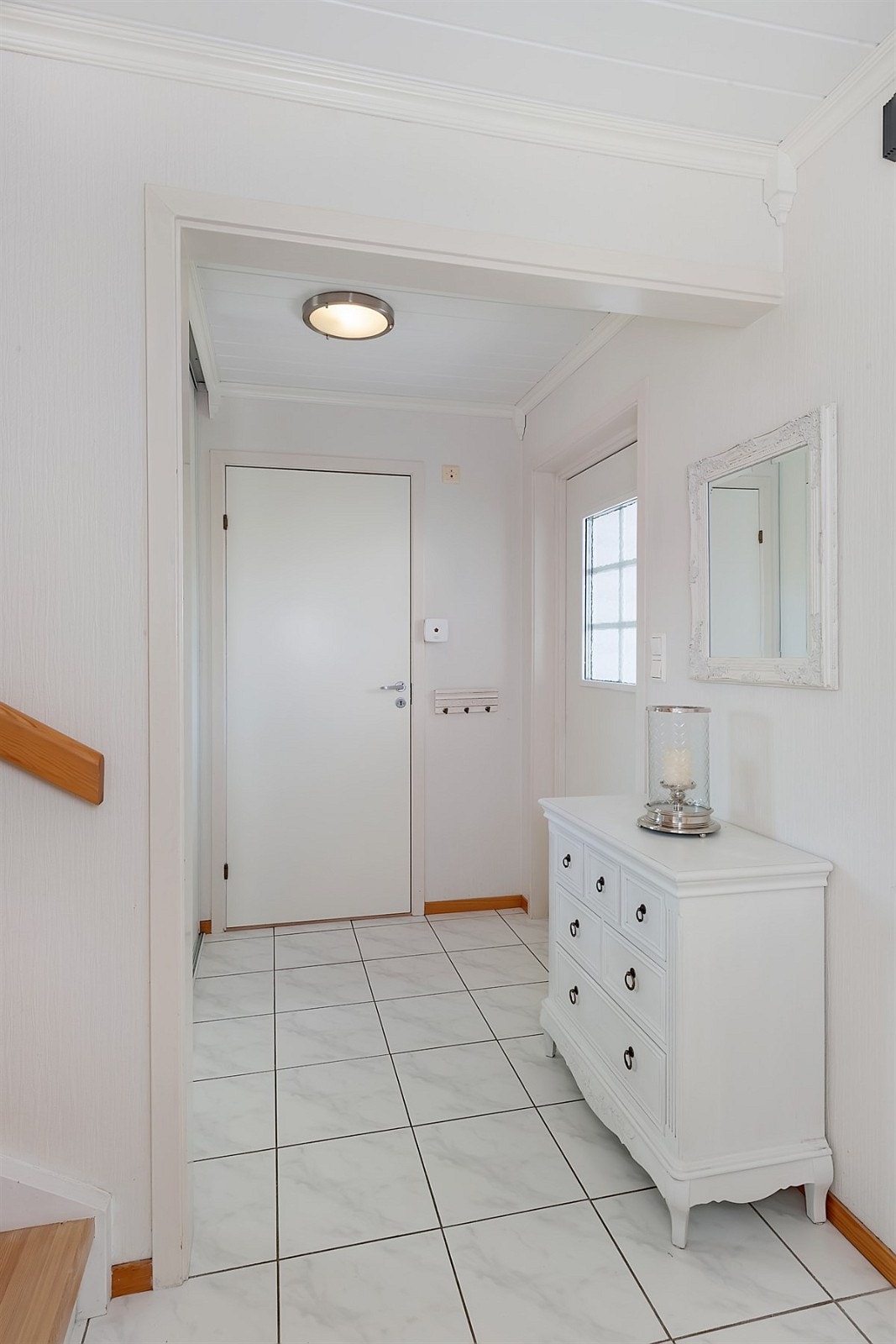 Entreen har fliser på gulv og stor skyvedørsgarderobe. Rommet har også gulvvarme, dagslys fra vindu i ytterdøren og alarmpanel. Videre er entreen direkte tilknyttet garderoberom/lagringsbod. Galleribilde