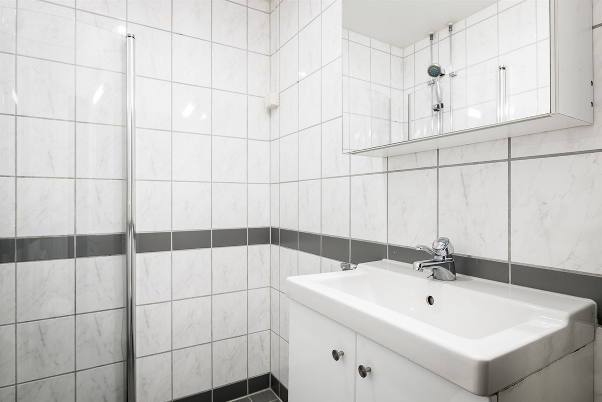 Badet ligger ytterst ved entréen, er arealeffektivt innredet og har plass til vaskemaskin i hjørnet. Galleribilde