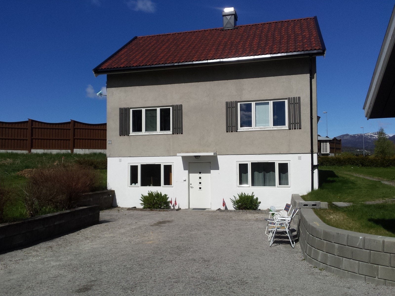 Huset utenfra. Det er 1.etasje/kjelleretasjen som leies ut. God plass til bilparkering på eiendommen. Galleribilde