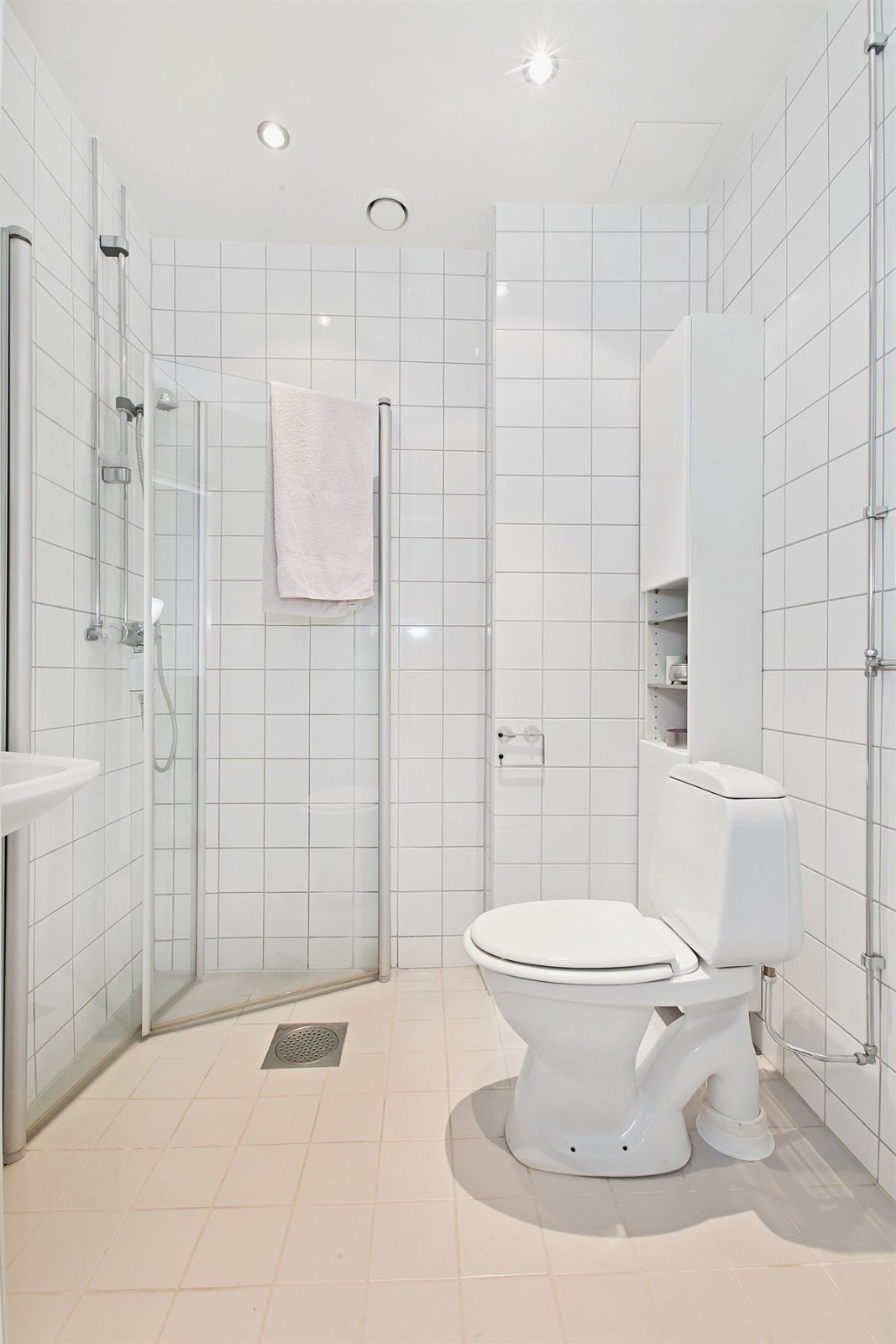 Baderommet er utstyrt med åpent dusjhjørne, servant, speil, veggskap samt toalett. Plass og opplegg til vaskemaskin. Varmekabler. Downlights. Galleribilde