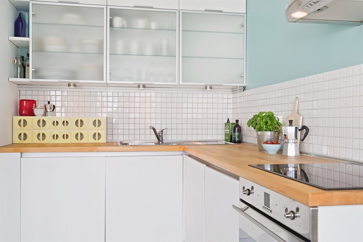 Det er rikelig med skap- og benkeplass i takhøy kjøkkeninnredning med hvite glatte fronter og heltre bøk benkeplate. Galleribilde