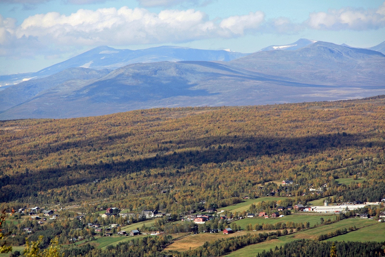 Skåbu er Nord-Europas høyestliggende bygdesamfunn. Det helhvite fjellet er Glittertind. Nautgardstind til venstre. Vegen Murudalsråket tar av ved husklynga lengst til venstre og går opp gjennom Heimstulen. FOTO: Anne Mari Lo Galleribilde