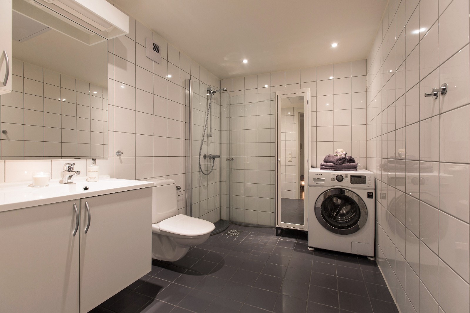 Pent og flislagt bad med heldekkende servant over underskap Galleribilde