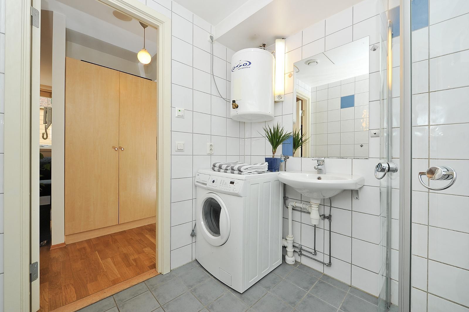 Pent flislagt bad med opplegg for vaskemaskin. Galleribilde