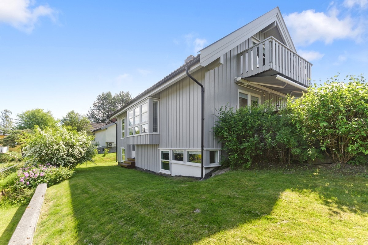 Fasade mot hagen bak. Utgang med tretrapp og godt med plen rundt. Galleribilde