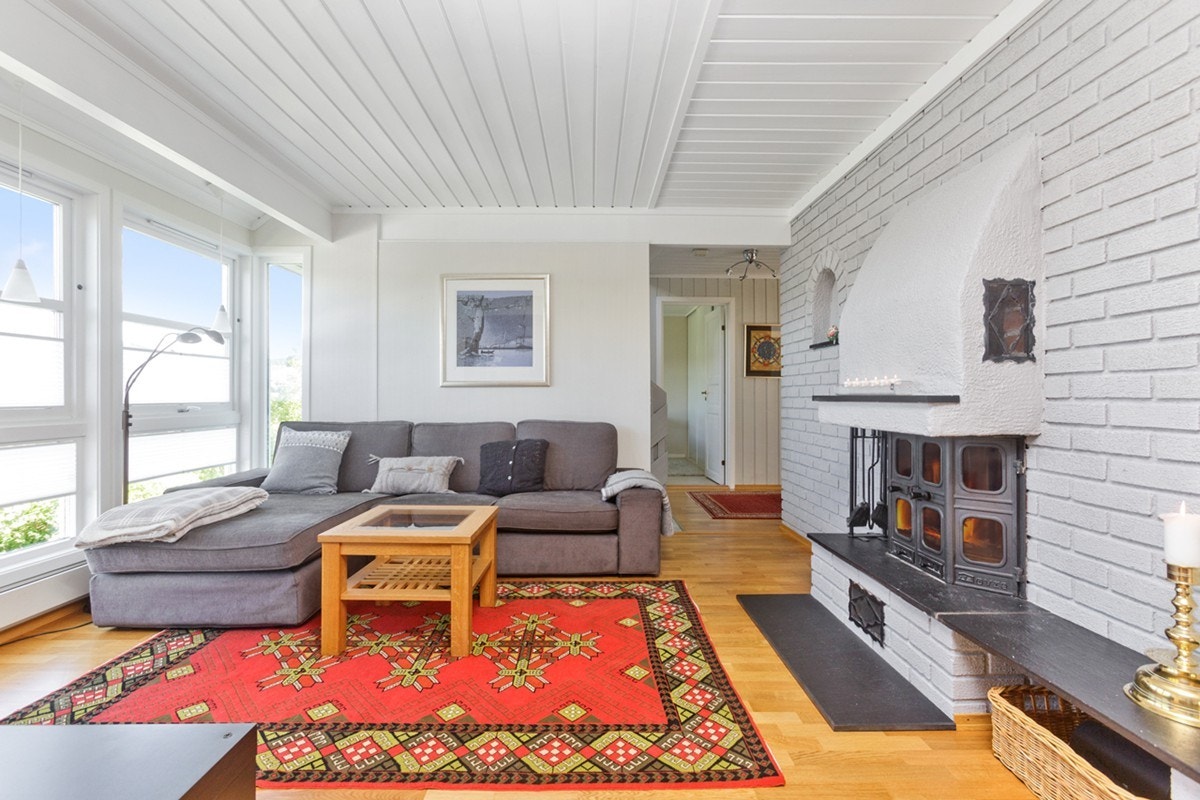 Stue mot hall. Murvegg med peis og godt med vinduer. Galleribilde