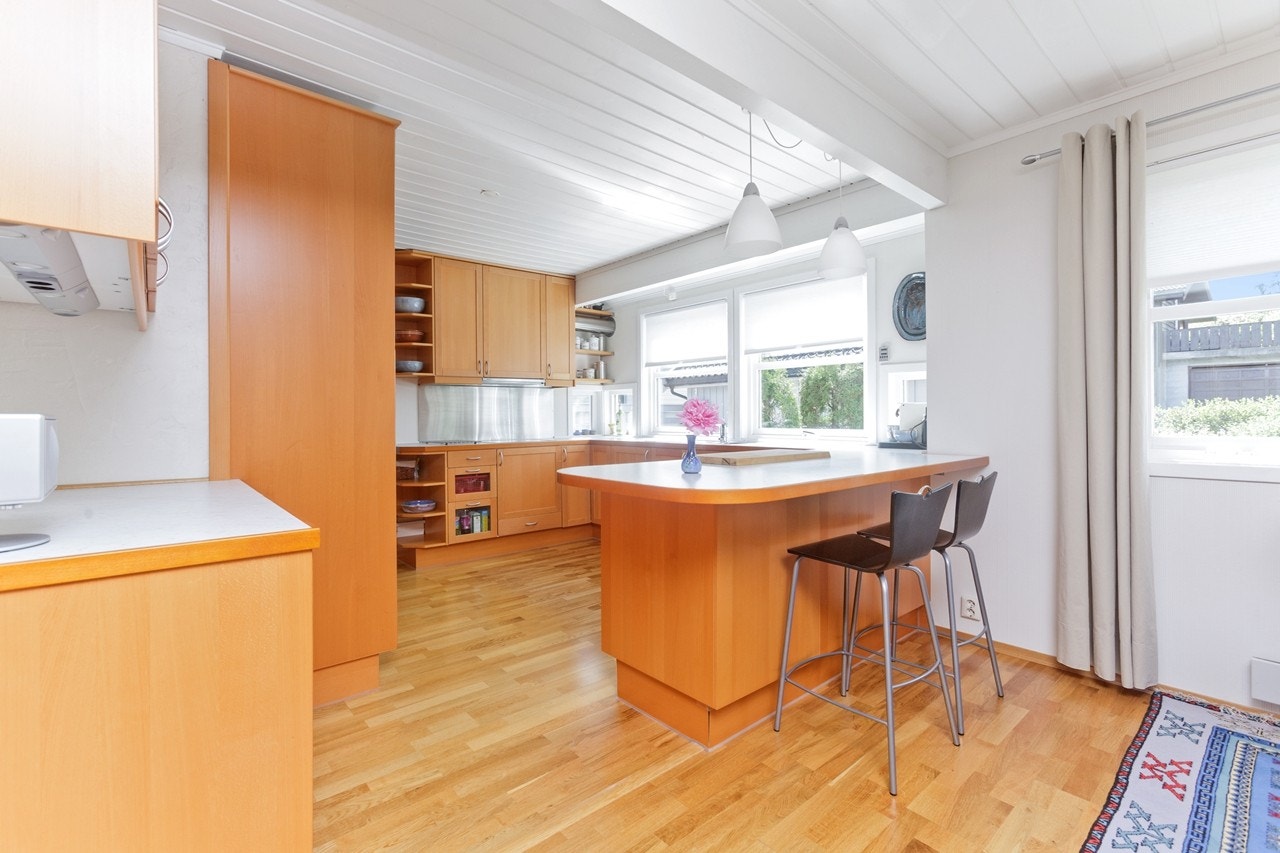 Kjøkkenet har en barbenk mot spisestuedelen. Galleribilde