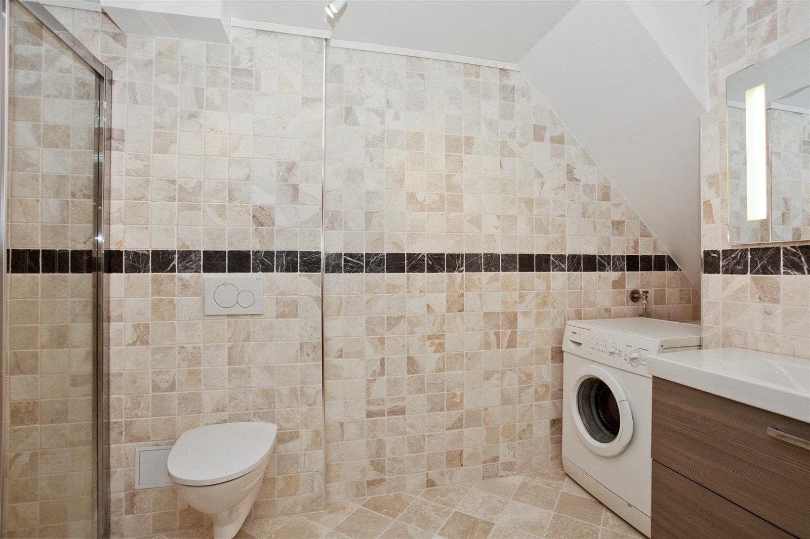 Nydelig bad i underetasjen med moderne innredning. Det er tilrettelagt for oppkobling av vaskemaskin på dette badet. Galleribilde