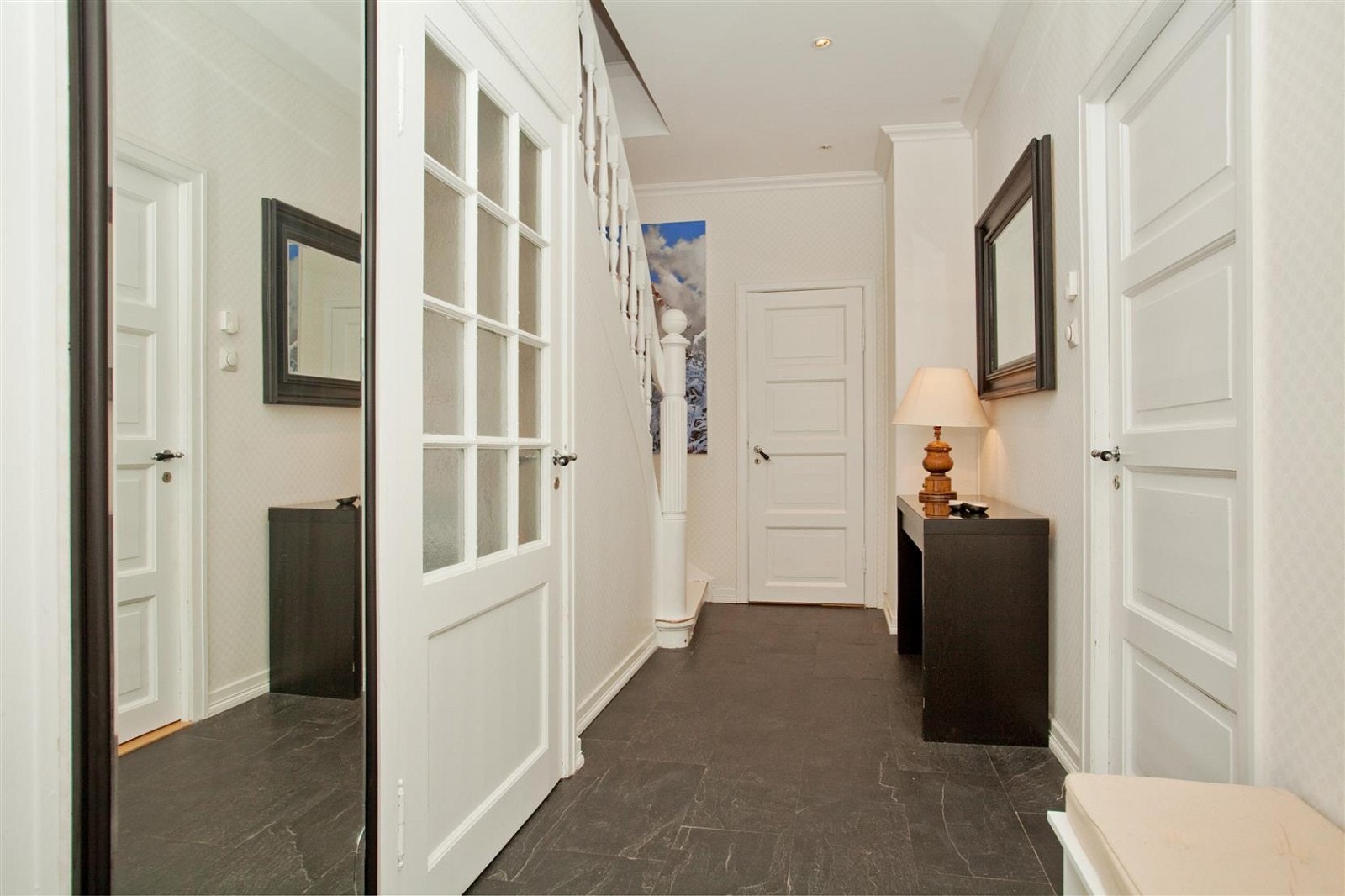 Innbydende hall med moderne skiferflis på gulvet (vannbåren gulvvarme) og himling med innfelte downlights. Galleribilde