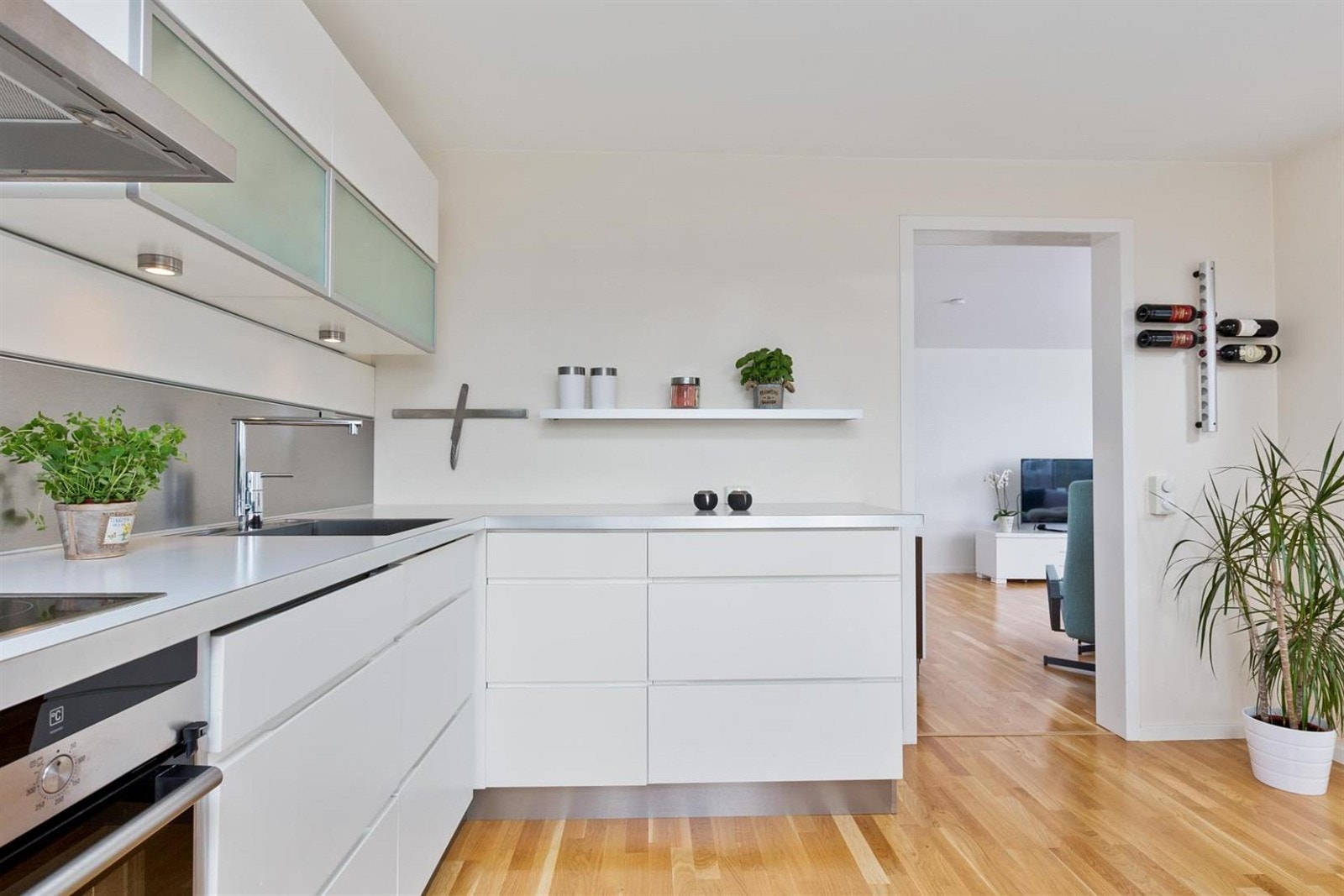 Kjøkken med laminat benkeplater og slette, malte fronter. Underlimt oppvaskkum i rustfri utførelse. Nedfelt keramisk platetopp og innebygget stekeovn samt oppvaskmaskin. Galleribilde