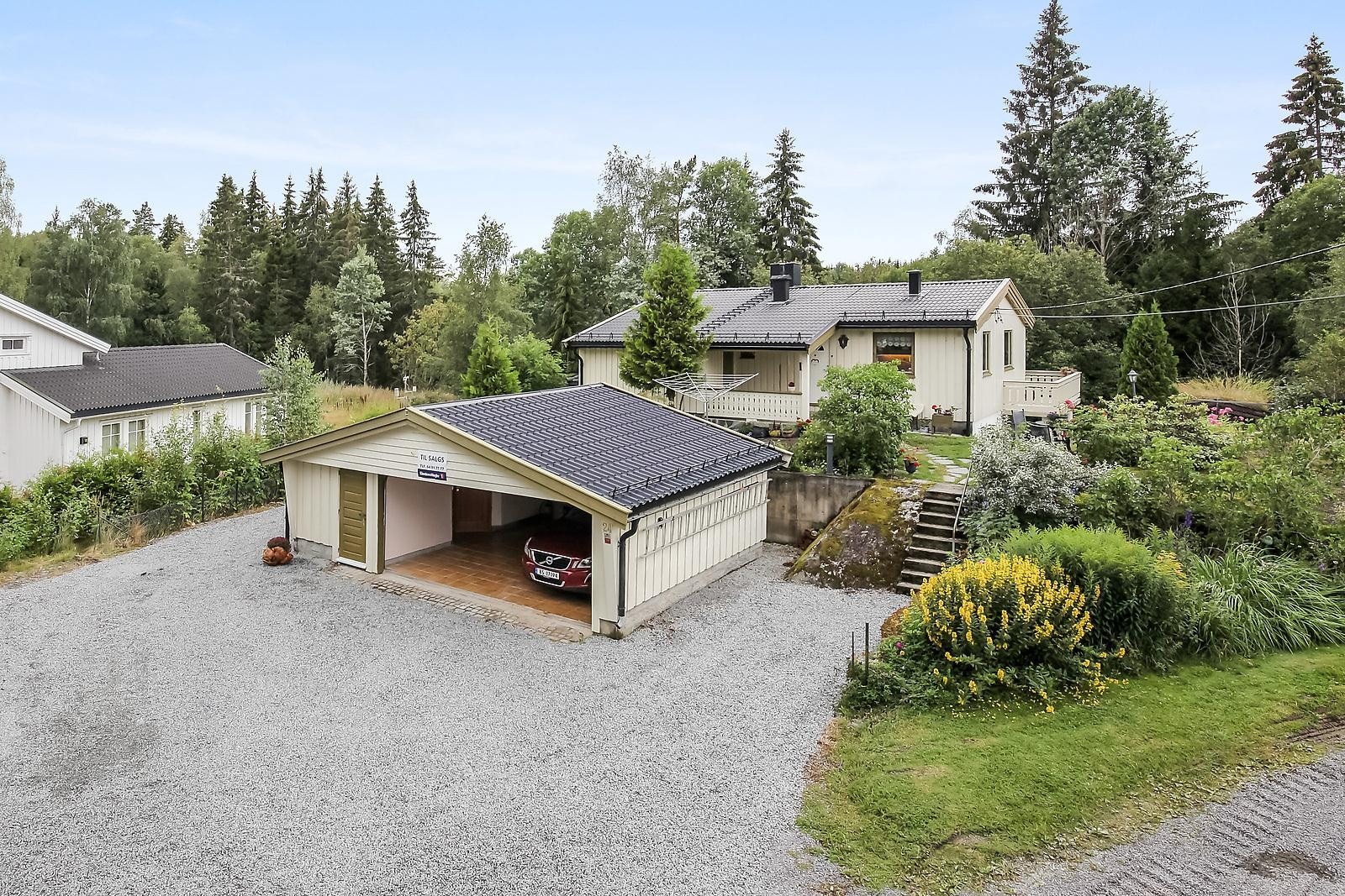 Stor og praktisk eiendom med dobbel garasje som er flislagt og har varmekabel i gulv der bilene står parkert. Galleribilde