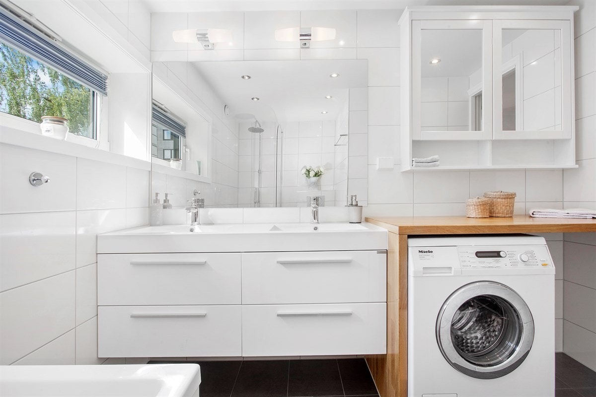 Boligen inneholder et delikat bad fra 2013. Med mørke fliser på gulv med gulvvarme, hvite fliser på vegg og downlights i tak. Galleribilde