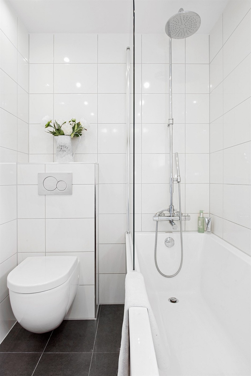 Badet er pent innredet og har speilskap med belysning, dobbel servant på hvitt servantmøbel, veggmontert toalett, samt badekar med dusjvegg og regnfallsdusj for ekstra velvære. Badet har også opplegg for vaskemaskin i nisje under benkeplate i eik. Galleribilde