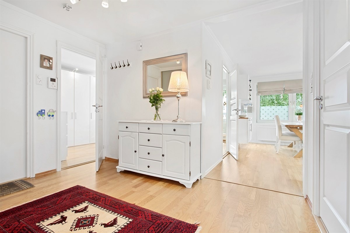 Entreen er åpen og innbydende med parkett på gulv. Rommet er praktisk innredet med videodørcalling, samt skyvedørsgarderobe og skoskap som gir bra med oppbevaringsplass Galleribilde