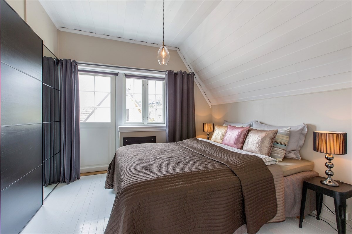 Et vakkert og intimt hovedsoverom med utgang til egen takterrasse. Lysmalte originalplanker på gulv, pusset mur og lysmalt himling gir en behagelig og fredfull atmosfære. Galleribilde
