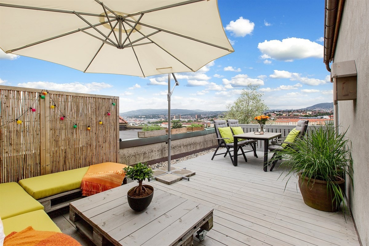 En lun lounge innerst og spiseplassen som bader i sol og utsikt ytterst. Med byen under deg og solnedgangene i front. Galleribilde