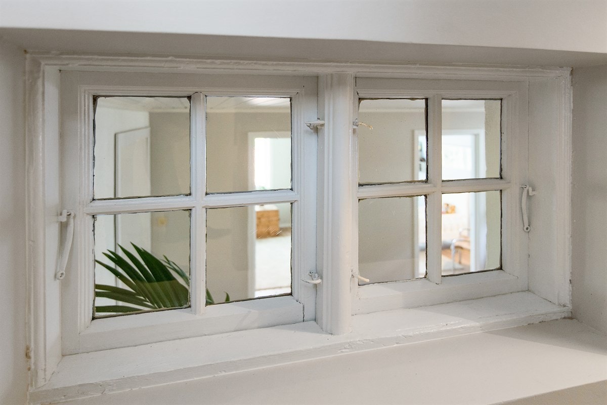 På vei ned trappen til underetasjen gir et gammelt vindu en liten snikktitt inn i den nye delen som ble påbygget i 1990. Galleribilde